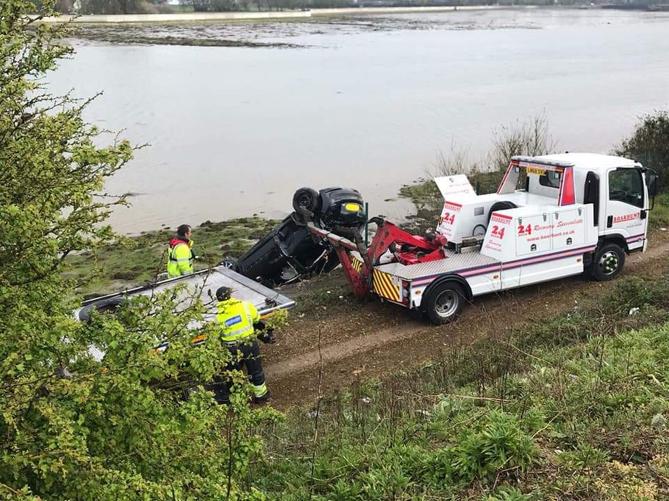 white recovery truck recovery a car from lake