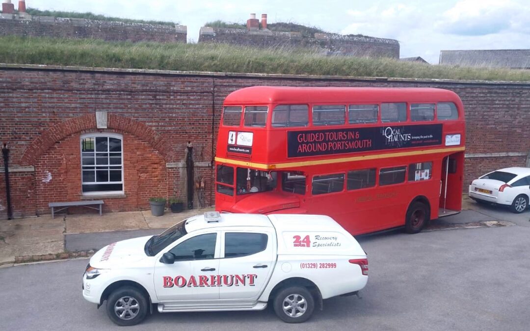 Red bus, white pick up truck and white car