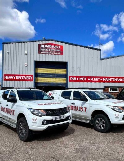 Two white pick up trucks side by side